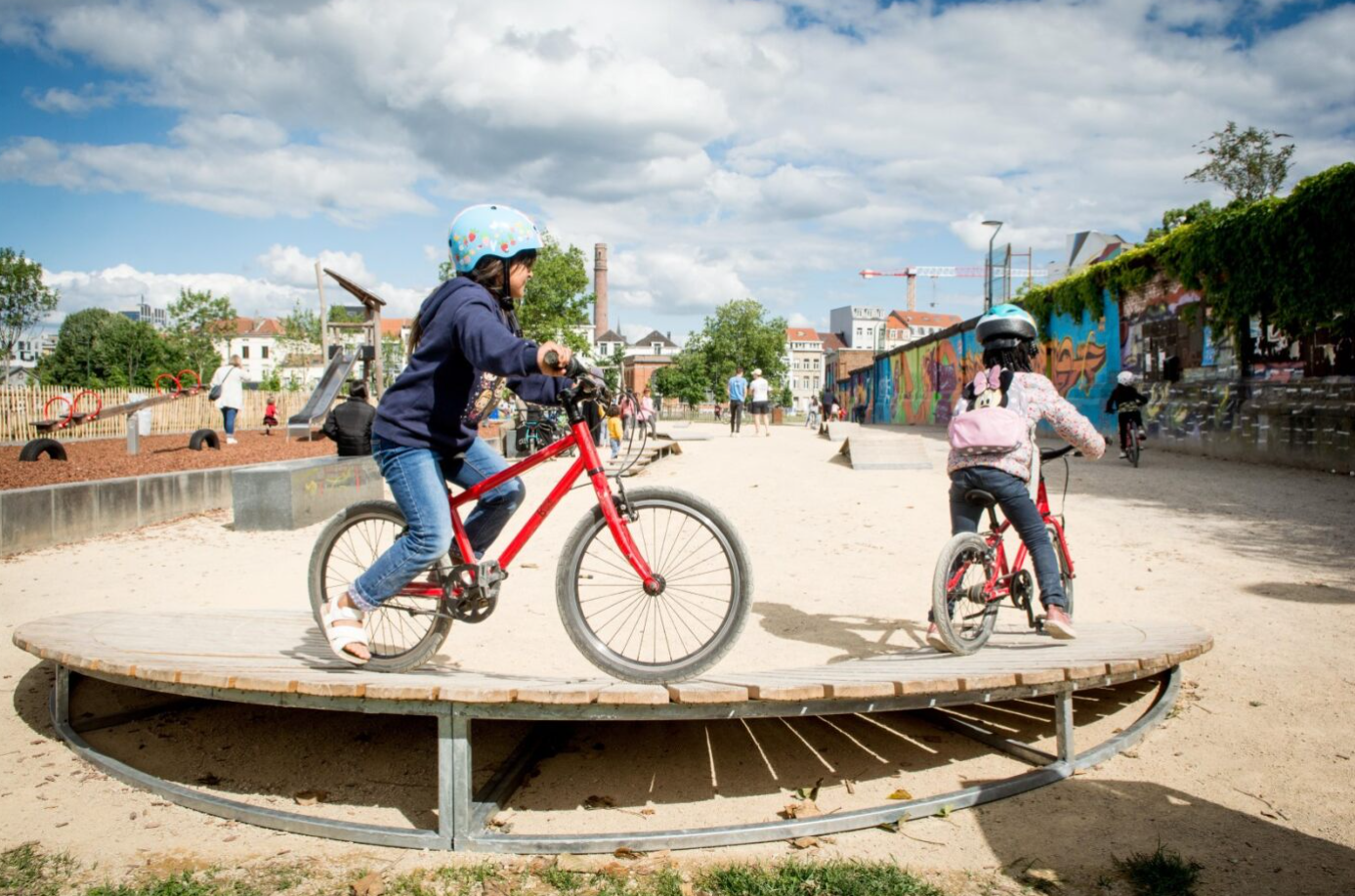 Des enfants à vélo sur un circuit bike park au parc de la Porte de Ninove.