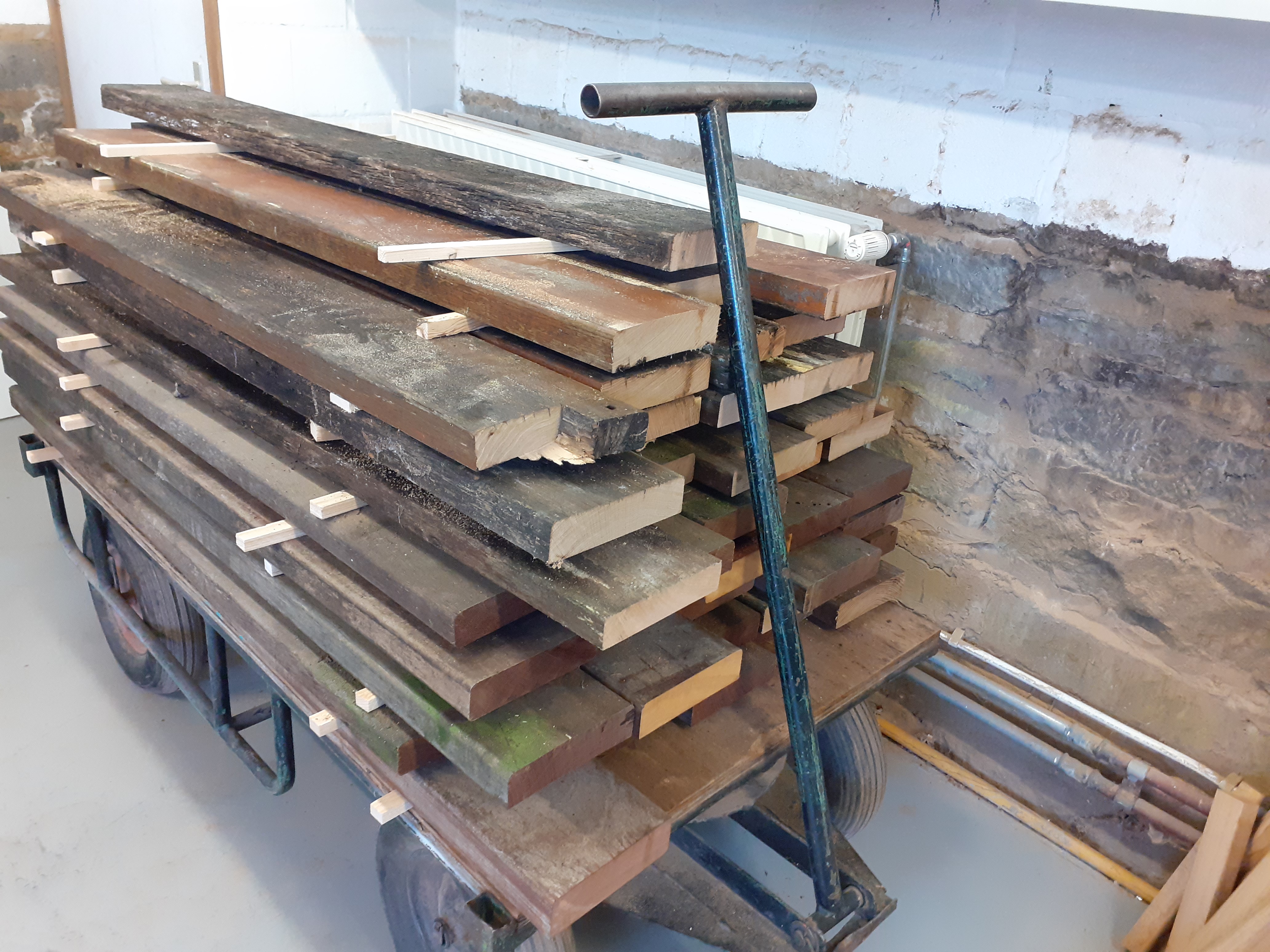 Un chariot chargé de planches en bois récupérées.