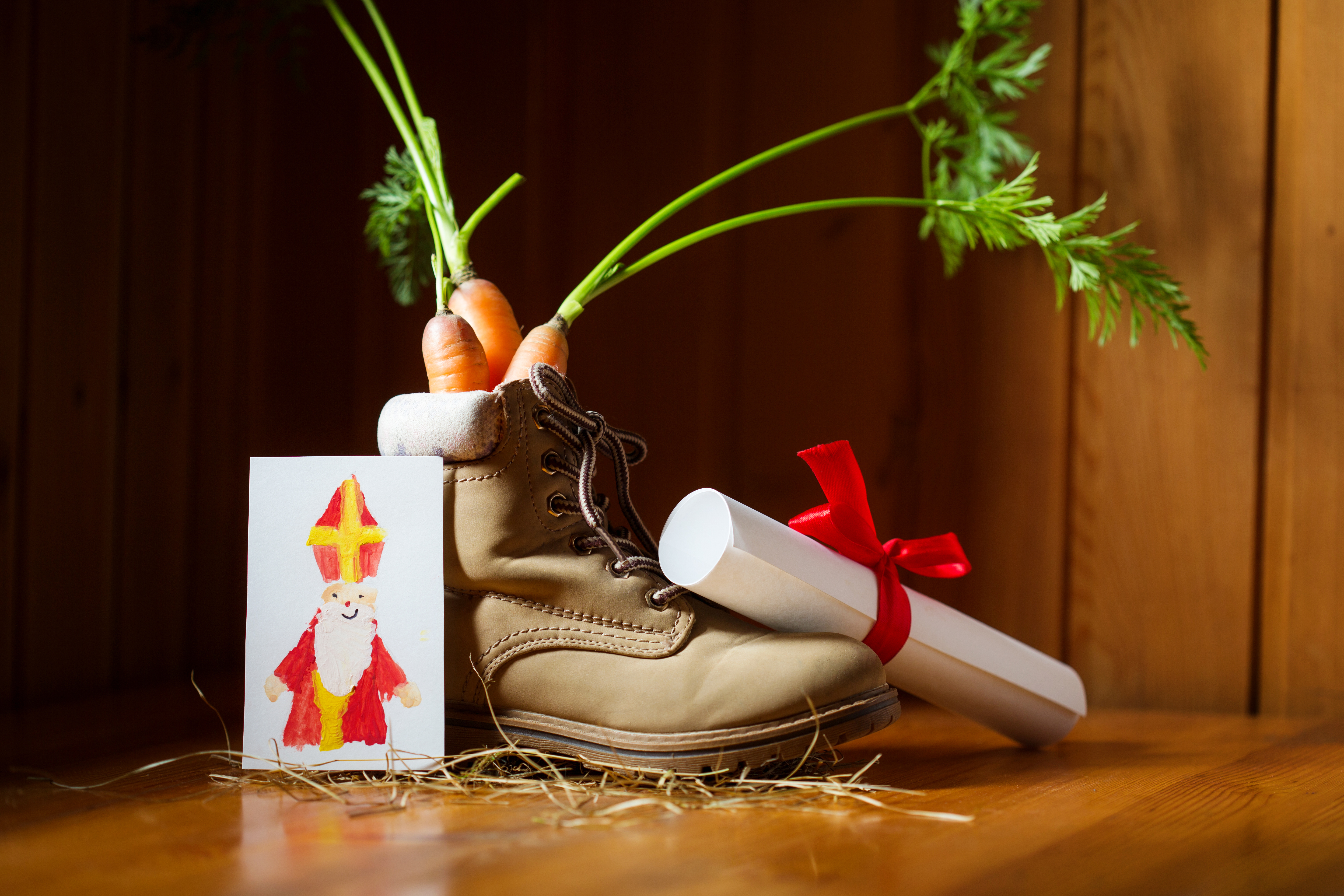 Chaussure d'enfant remplie de 3 carottes et entourée d'une lettre et d'un dessin pour Saint-Nicolas.