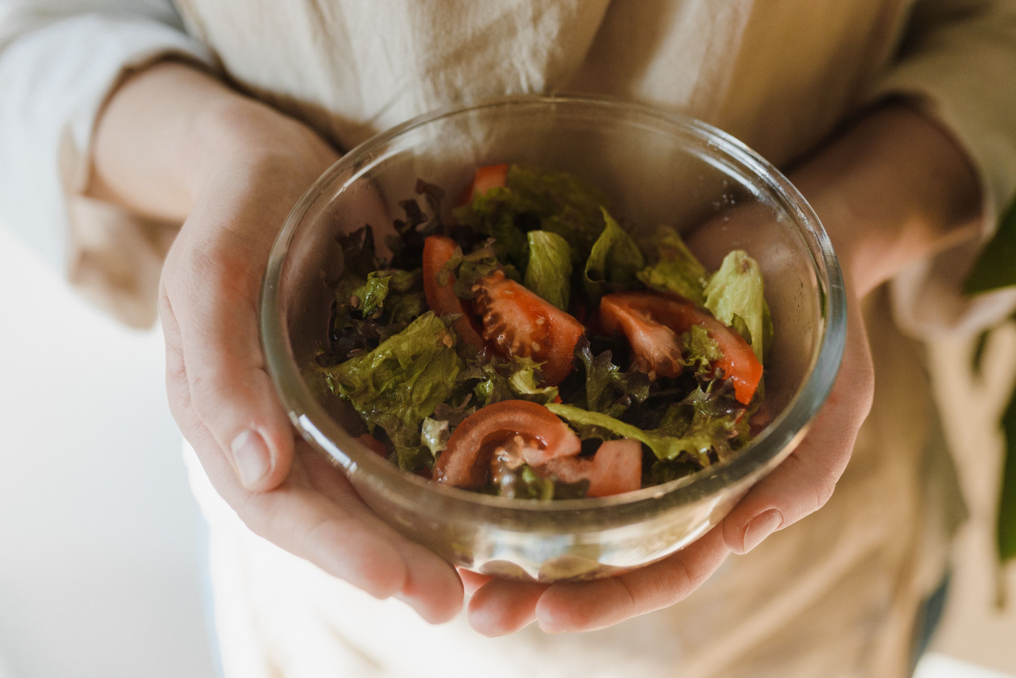 Une personne tient un bol réutilisable de salade