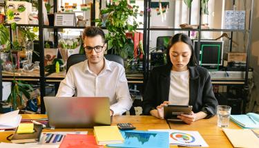 Un homme devant son ordinateur, une femme devant sa tablette