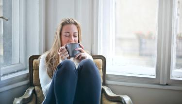Personne qui boit une tasse de thé chaud