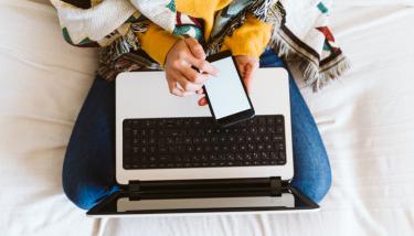 Femme sur un fauteuil avec un pull chaud et une couverture
