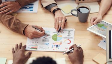 Personnes doncultent des documents autour d'une table