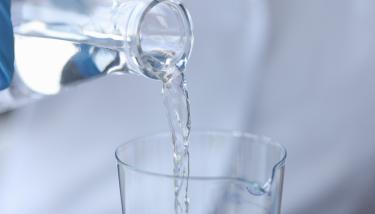 De l'eau versée d'un carafe dans un verre d'eau